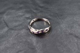 A silver band ring having amethyst and diamond chip decoration in twist mount, size S/T and approx