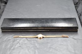 A lady's 9ct gold Rotary wrist watch having baton numeral dial to circular champagne face in gold