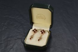 A pair of 9ct gold antique style garnet and seed pearl stud earrings having cluster studs with drops
