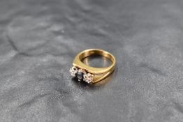 A sapphire and diamond trilogy ring having central sapphire flanked by two diamonds in illusionary