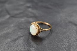 An opal ring having an oval stone in a collared mount on a 9ct gold loop, size L & approx 1.9g