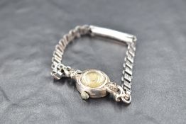 A ladies 9ct white gold cocktail watch by EMKA having baton numeral dial to small face in a white