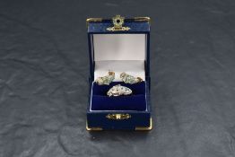 A 9ct gold panther ring with matching stud earrings, all having emerald and diamond chip decoration,