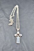 A silver cross pendant of Celtic form having central garnet, on a silver chain, approx 16' & 10.8g