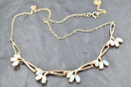 A 9ct gold and opal necklet, having five stylised foliate links each set with marquise shaped opals,