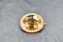 A citrine brooch having a seed pearl surround in a yellow metal mount, presumed gold, approx 7.3g