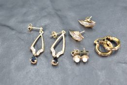 Four pairs of 9ct gold stud earrings of various forms including cubic zirconia set hoops, diamond