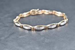 A 9ct white and yellow gold articulated bracelet having eleven panels each containing twelve small