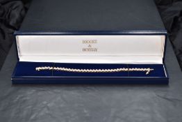 A 9ct white and yellow gold articulated bracelet having thirty eight diamond set panels, totalling