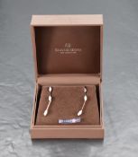 A pair of 18ct white gold stud earrings, each having a trio of trios of diamonds on bar drops, total