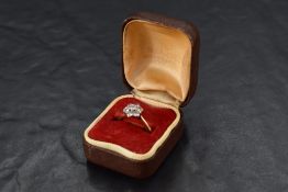 A diamond daisy cluster ring, total approx 0.5ct in a raised claw mount to knife blade shoulders