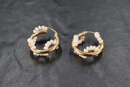 A pair of yellow metal hoop earrings stamped 14K having seed pearl decoration, approx 4.1g
