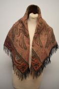 A 19th century woven wool shawl, having Paisley pattern and fringed edges.