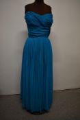 A 1950s strapless evening gown in blue crepe georgette, with gathered cross over bust, cummerbund