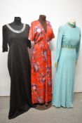 Three 1960s to 1970s maxi dresses, including floral red dress with fluted sleeves and mint green