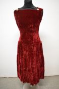 An early 1950s claret velvet dress, having tiered skirt, square neckline with button accents and