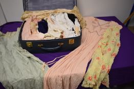 A suitcase full of mixed vintage and antique clothing, including 1930s nightwear, AF, wear and