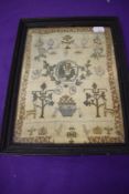 An antique needlework sampler, depicting animals and plants, undated, appears to be early 19th