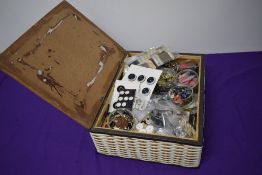 A wicker basket containing a huge assortment of vintage haberdashery, including many, many