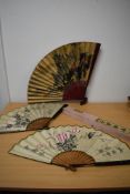 A trio of vintage oversized oriental paper fans, one boxed.