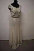 A 1940s ivory crepe evening gown, having sequin detailing to neckline, side metal zip and integrated