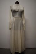 A 1930s cream crepe dress, having high neckline with smocking to shoulders, self covered buttons