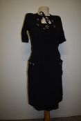 A 1940s black crepe dress, with floral sequin accents, pockets to front and shirred waist, has the