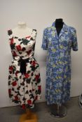 A 1950s day dress having bold rose pattern, tulip shaped skirt with bow detail and rear metal