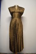 A 1950s bronze dress, having pleated bodice and skirt, side metal zip and Coopella label.