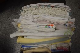 A box full of vintage table linen etc, including embroidered and crotchet edged examples.