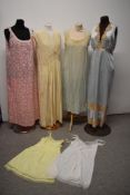 Two nylon slips, a 1960s cotton nightdress, two circa 1930s nightdresses, AF, some wear and a pale