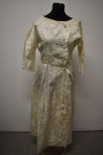 A 1950s wedding dress, having self covered button fastening to front with scalloped edge and half