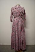 A 1950s crisp cotton pink floral house coat having navy blue, white and grey floral pattern, with