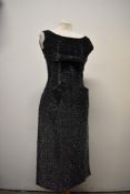 A late 1950s black evening dress with metallic thread detailing, rear metal zip, bow to under bust