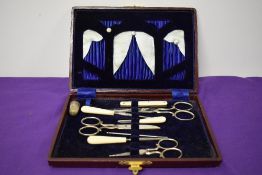 An Edwardian boxed sewing set, including boned handled knife, crotchet hook, scissors and thimble