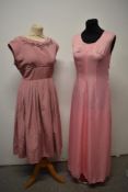 A 1950s grosgrain dress in rose pink, having full plated skirt, beading to bust and half belt to