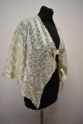 An Edwardian bed jacket of bands of lace interspersed with mint green silk.