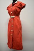 A 1950s medium weight textured cotton red pencil dress, having white piping, collar and belt