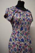 A late 1930s/early 1940s cotton day dress having cheerful floral pattern and ruffled neckline with