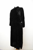 An Art Deco black velvet dress, having high neckline, gathers to shoulder and hip, rear self covered