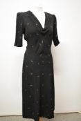 A 1930s black crepe day dress having simple metallic gold and red painted design, V neckline,