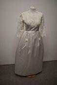 An early 1960s wedding dress having scoop neckline, floral detailing to upper bodice and three