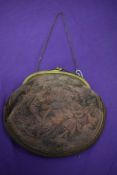 A large early 20th century over dyed petit point bag, having brass frame and chain strap.