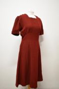 A simple yet highly effective 1940s burgundy day dress having half belt with button to back, no