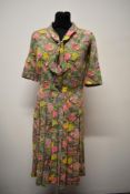 A colourful late 1950s cotton day dress, having pleated skirt and neckerchief style detail, larger