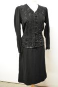 A late 1930s/40s black crepe dress having extensive beadwork to bodice, self covered buttons to