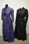 A Victorian two piece outfit in patterned black fabric, and a blue and black striped Victorian