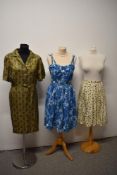 A 1950s day dress having buttons to front and side metal zip, motif pattern in brown, mustard and