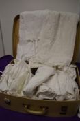A suitcase of Victorian to 1950s items, included are petticoats, slips, corset covers etc, some