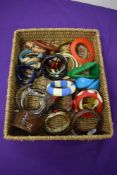 A basket full of mixed vintage and modern bangles, predominantly plastic, many colours and styles.